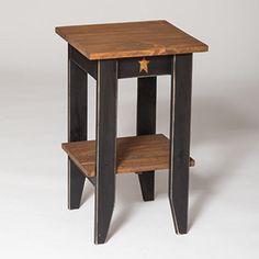 a small wooden table sitting on top of a tile floor next to a white wall