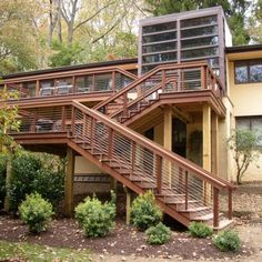 a house with stairs leading up to the second floor and another level on top of it