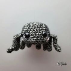 a crocheted black and white spider with big eyes