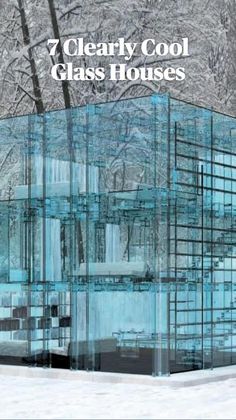 a glass building sitting in the middle of a snow covered forest