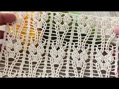 someone is crocheting lace on the edge of a piece of cloth