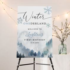 a welcome sign sitting on top of a easel in front of a christmas tree