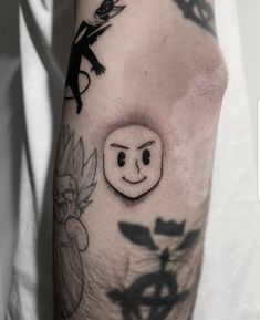 a person with a tattoo on their arm has a smiley face in front of him