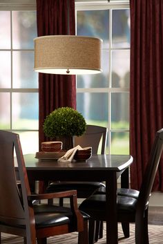 a dining room table with chairs and a potted plant