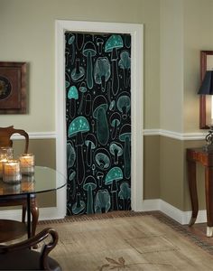 a room with a glass door that has green and black designs on it, along with candles