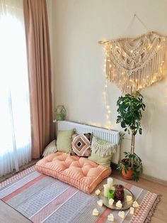 a room with a bed, rug and potted plant on the floor next to it