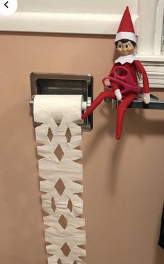 an elf is sitting on top of a toilet paper roll