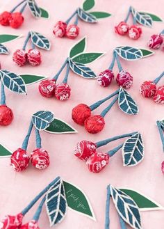 red and blue cherries with green leaves on a pink tablecloth covered in white frosting