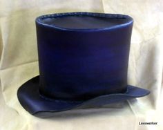 a blue top hat sitting on top of a white sheet