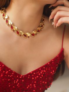 levate your style with the Ruby-Red Elegance Necklace, a stunning accessory designed to capture attention. This exquisite piece features a striking combination of ruby-red stones and golden elements, elegantly arranged in a unique and contemporary pattern. Perfect for adding a touch of sophistication and luxury to any outfit, whether for a special occasion or daily wear. Details: Material: Brass with gold plating Length: 33 cm with an additional 9 cm extension chain Weight: Approximately 46 g Care Instructions: To maintain the beauty and longevity of your necklace, avoid direct contact with water, perfumes, or chemicals. Red Ruby Necklace Vintage, Elegant Red Necklace With Vintage Charm, Red Ruby Necklace With Intricate Design, Elegant Ruby Necklace With Hand-set Stones, Elegant Red Brass Necklace, Red Stone, Ruby Red, Vintage Necklace, Daily Wear