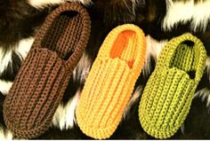 three crocheted slippers sitting on top of a fur rug