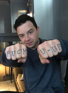 a man pointing his fingers at the camera with words written on their thumbnails