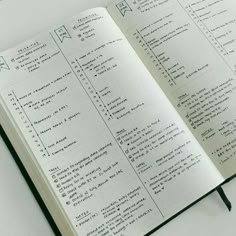 an open notebook with some writing on the pages and numbers in each page, sitting on top of a white table