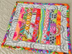 a close up of a colorful quilt on a bed