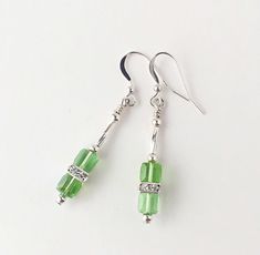 I love cube shaped Swarovski crystals because of the modern contemporary look they give to jewelry. These beautiful dangle earrings are made up of two cube peridot green crystals separated by flat square rhinestone sterling silver beads. Two sterling silver twisted tube beads add more sparkle. They hang from comfortable silver fishhook ear wires and measure approximately two inches long. These earrings will bring you many compliments with their soft sparkle and unique design!      Your purchase Cube Beads Jewelry Ideas, Earring Design Ideas, Dark Blue Jewelry, Dark Blue Earrings, Earrings Tutorial, Simple Crafts, Diy Jewelry Necklace, Blue Dangle Earrings, Peridot Green