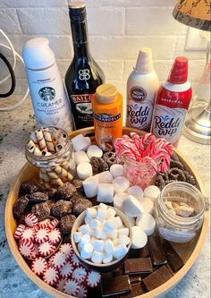 a tray filled with hot chocolates, marshmallows and candy