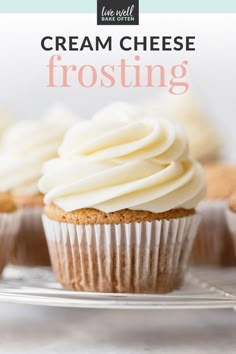 some cupcakes with white frosting sitting on top of a cooling rack and the words cream cheese frosting above them