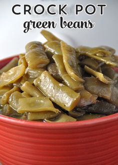 a red bowl filled with green beans on top of a white tablecloth and text overlay reads crock pot green beans