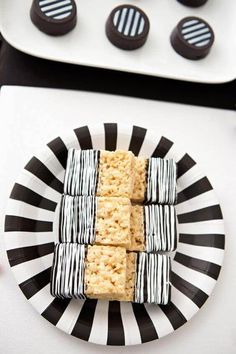 there are some cookies on the plate with chocolates in the background and one is made out of rice krispy kreme