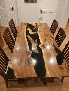 a wooden table with chairs around it in the middle of a floored room area