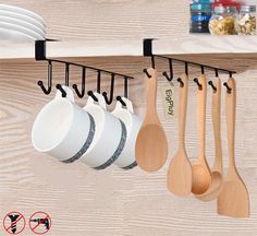 wooden spoons and spatulas are hanging on the wall