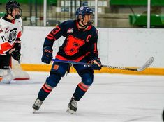 two young men playing ice hockey on an indoor rink