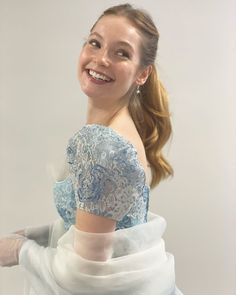 a woman in a blue and white dress smiling