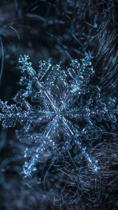 a snowflake is shown in the dark with some light shining on it's surface