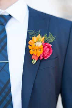 a man wearing a suit and tie with flowers in his lapel flower boutonniere