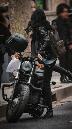 a woman sitting on the back of a motorcycle