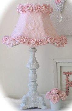 a lamp that is on top of a table next to a vase with flowers in it