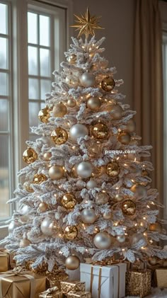 a white christmas tree with gold and silver ornaments