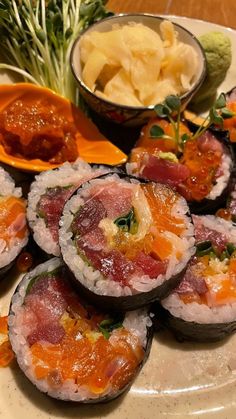 sushi is served on a plate with dipping sauce