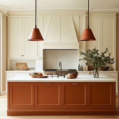 a kitchen with two hanging lights over the island