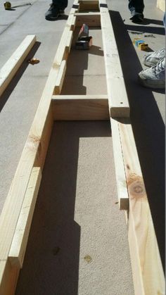 two men are working on some wooden planks