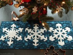 a christmas tree is decorated with snowflakes and gingerbread cutters for the holiday season