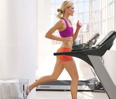 a woman is running on a treadmill