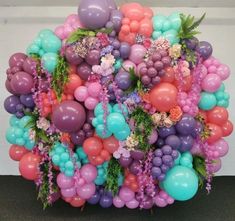 a bunch of balloons that are in the shape of a flower pot with flowers on them