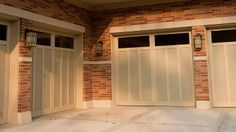 two garage doors are open in front of a brick building