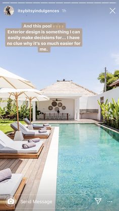 a pool with lounge chairs and umbrellas next to it, in front of a house