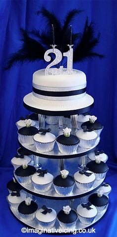 a tiered cake with cupcakes on it and the number twenty is displayed