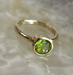 Genuine Peridot in 14K Solid Gold Ring Natural Peridot Natural Color Solid 14K Gold (not gold plated/ not gold filled) Round Stone 8 mm in Diameter. (9.7mm with the bezel) Weighs approximately 4.5 grams Band thickness is about 2.25mm Beautifully Faceted Bezel Set Made in La Jolla, California Ships from La Jolla, California FREE Shipping in USA Gold Rings With Smooth Bezel And Round Stone, Classic Green Jewelry With Smooth Bezel, Peridot Round Birthstone Ring For Formal Occasions, Yellow Gold Birthstone Ring With Smooth Bezel As Gift, Yellow Gold Birthstone Ring With Smooth Bezel, Formal Round Peridot Birthstone Ring, Anniversary Yellow Gold Birthstone Ring With Smooth Bezel, Formal Peridot Birthstone Ring, Classic Solitaire Peridot Jewelry