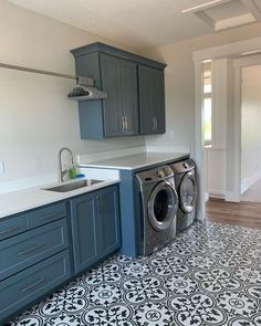 a washer and dryer are in the middle of a kitchen with blue cabinets