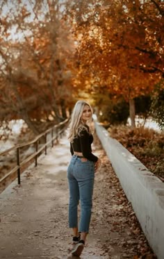 a woman standing on a path in the fall