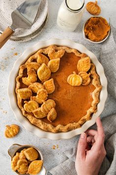 a pie with pumpkins on top and some other ingredients around it, ready to be eaten