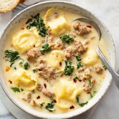 a white bowl filled with pasta and meat soup on top of a marble countertop