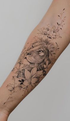 a woman's arm with a lion and flowers on it