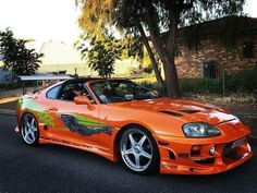 an orange sports car is parked on the street