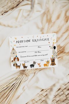 a certificate with animals on it sitting on top of a bed covered in white sheets