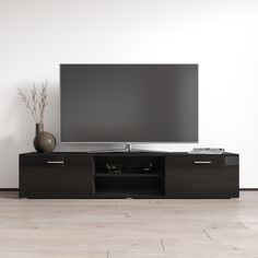 a flat screen tv sitting on top of a black entertainment center next to a vase